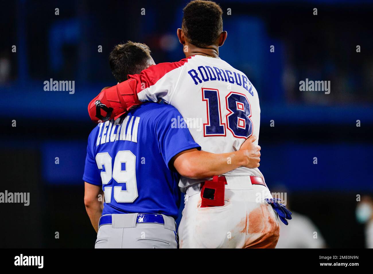 Israel's Alon Leichman, left, and the Dominican Republic's Julio Rodriguez  embrace after a baseball game at the 2020 Summer Olympics, Tuesday, Aug. 3,  2021, in Yokohama, Japan. The Dominican Republic won 7-6. (