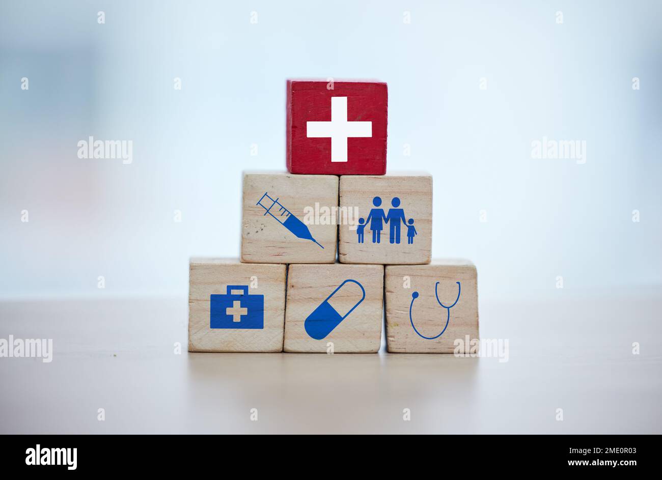 Health, insurance and wooden blocks in studio on an empty gray background for safety or security. Abstract, medicine and healthcare with block toys in Stock Photo