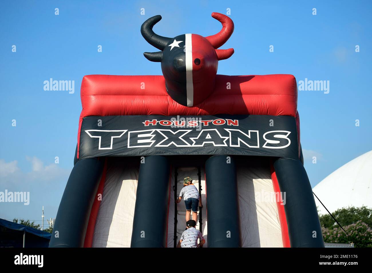 Houston Texans Inflatables Kids climb up an inflatable slide at a Texans training camp event ...