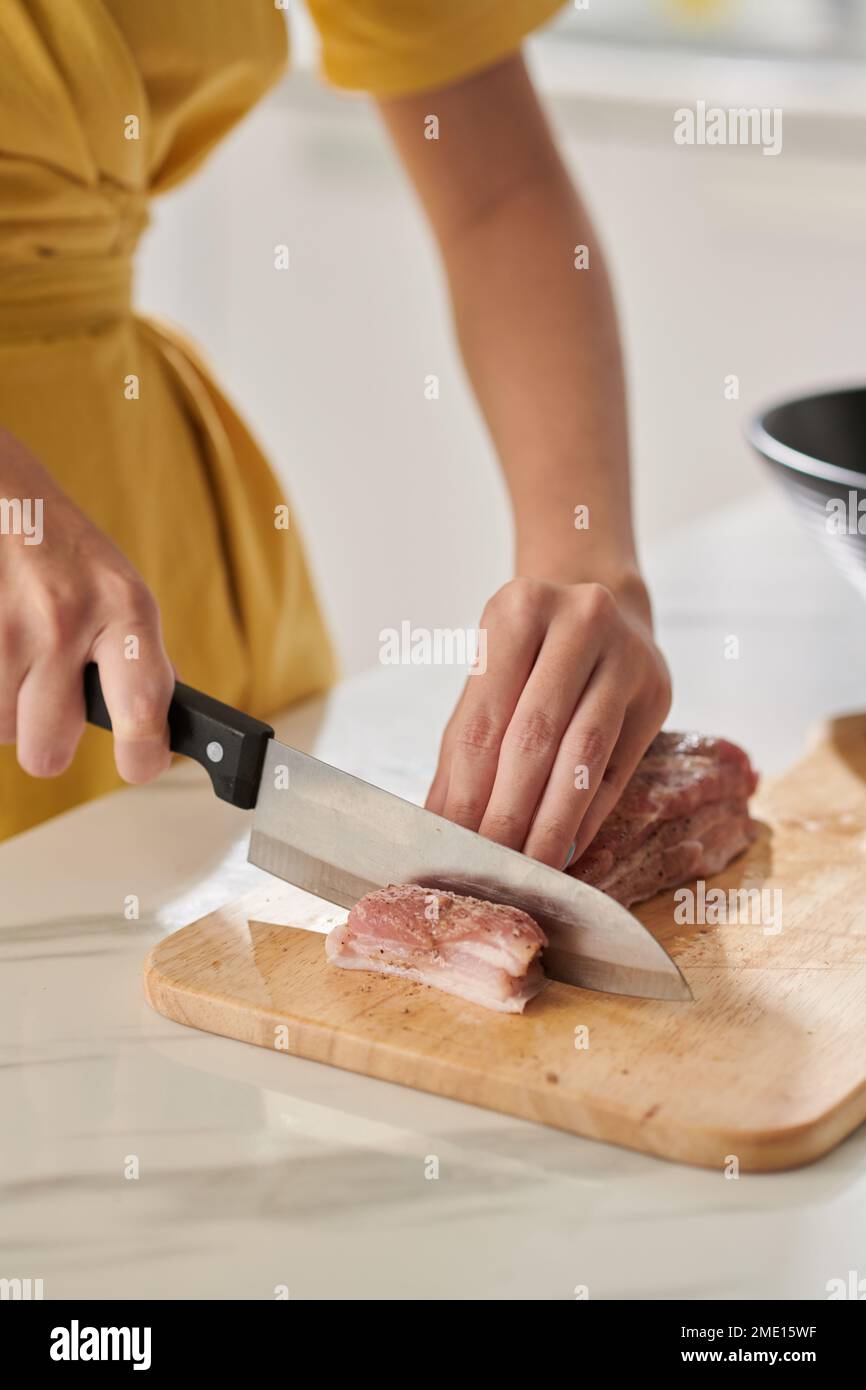 Hands of woman cutting seasoned pork for sticky rice cake Stock Photo