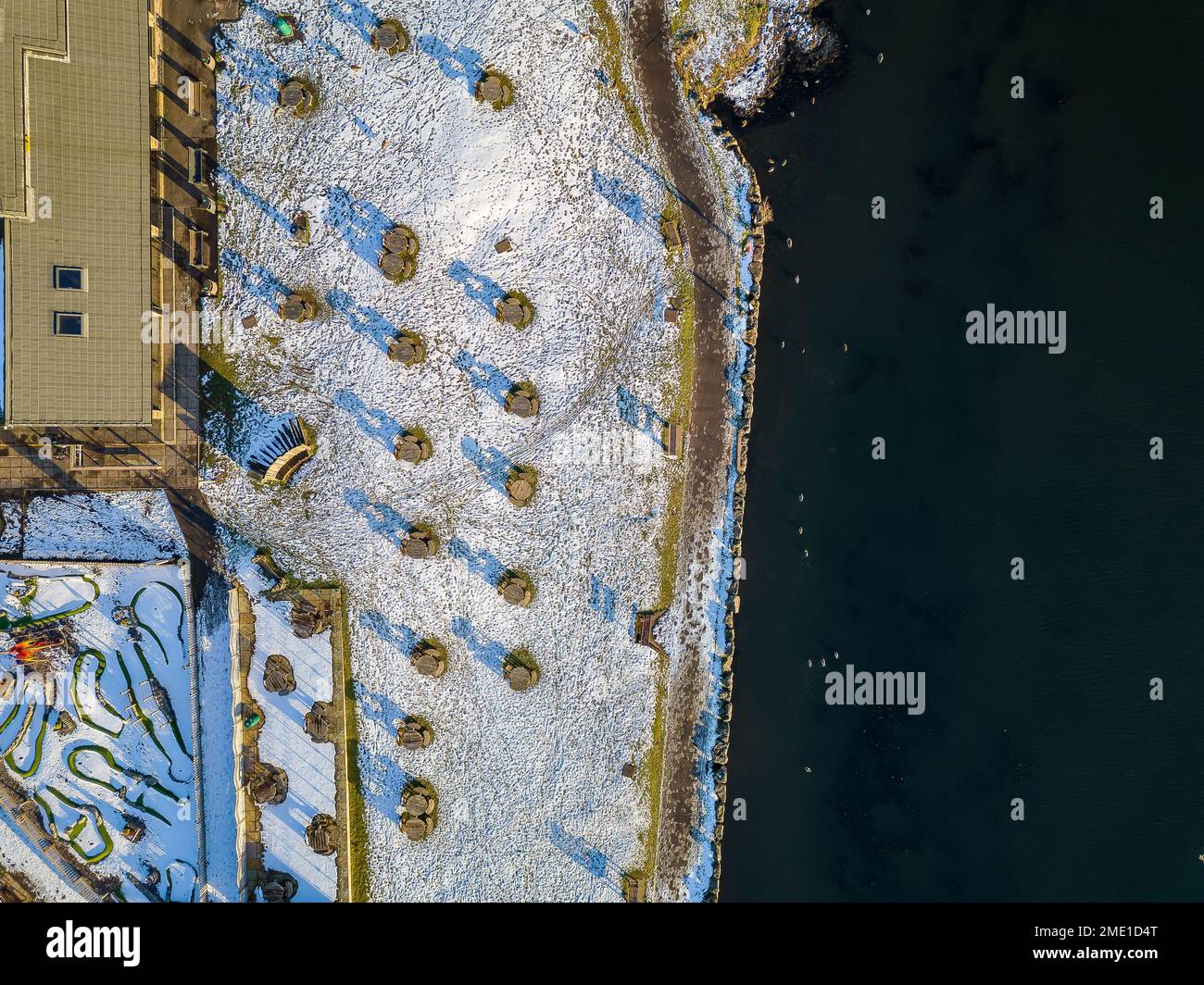 Aerial view of a freezing lake surrounded by snow in the South Wales Valleys (Bryn Bach) Stock Photo