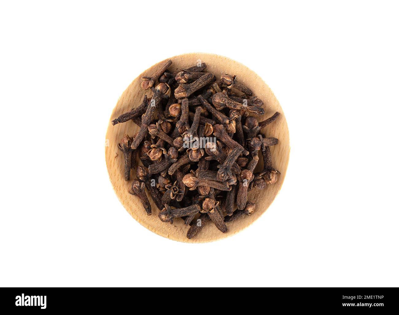 Top view of clove spice on wooden plate over white background. A spice