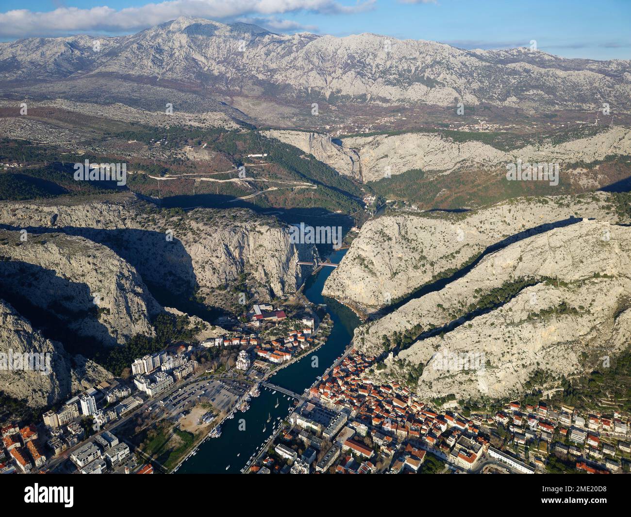 Aerial drone view of Omis town in Croatia. Location is where the Cetina River meets the Adriatic Sea.  Beautiful city next to the mountains. Stock Photo