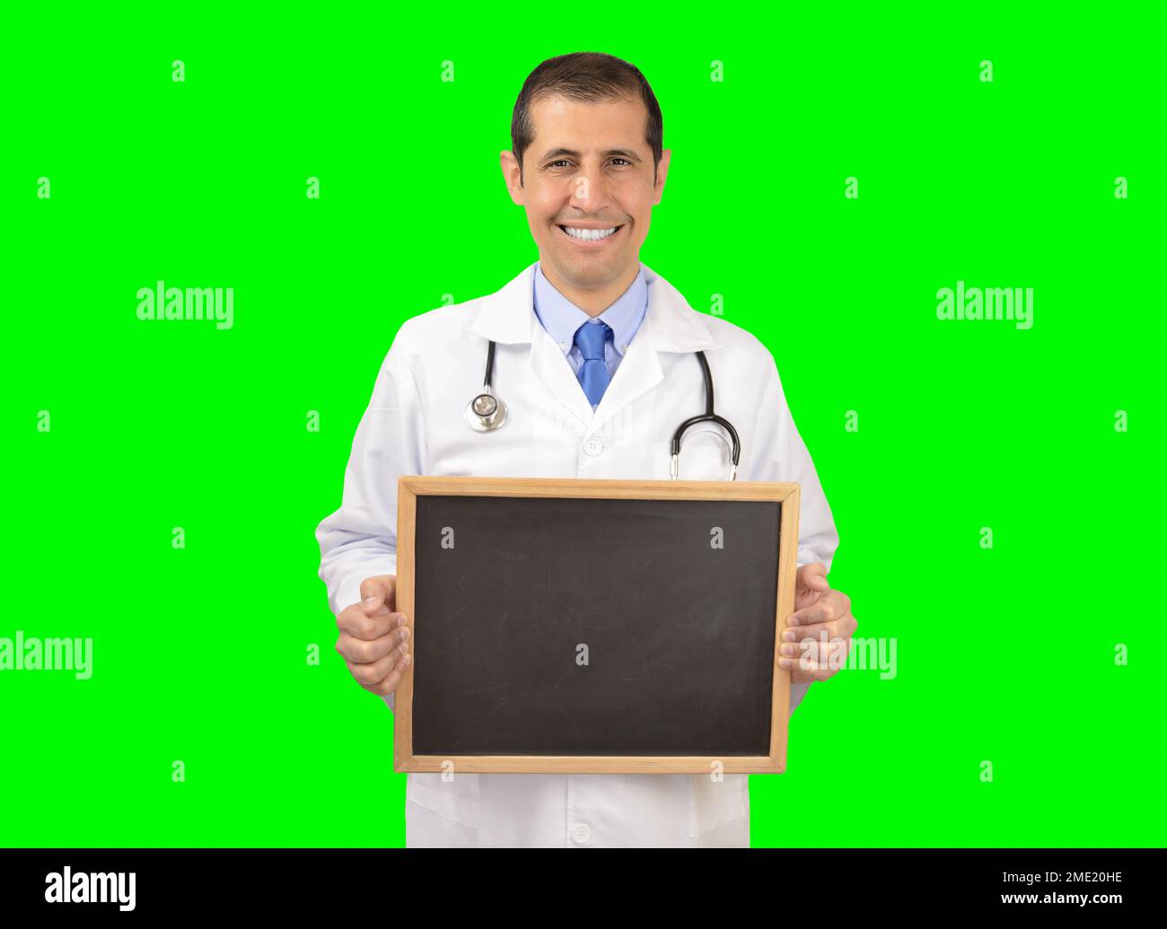 Doctor standing and smiling with chalkboard with copy space.Isolated cutout on green background with chroma key Stock Photo