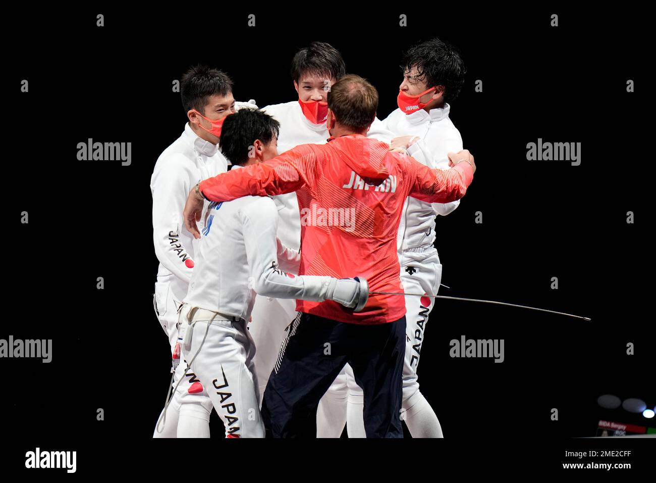 Japanese Epee team celebrate with their coach defeating Russian Olympic
