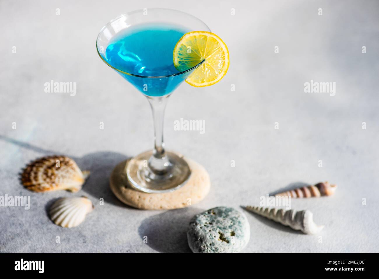 Glass of blue kamikaze drink on stone in modern style Stock Photo - Alamy