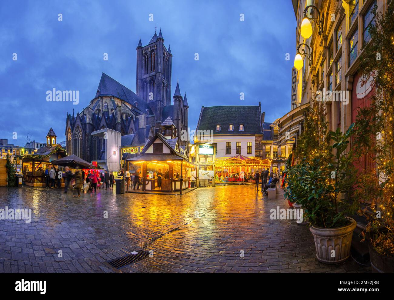 Ghent Christmas market with glowing lights in evening town near old