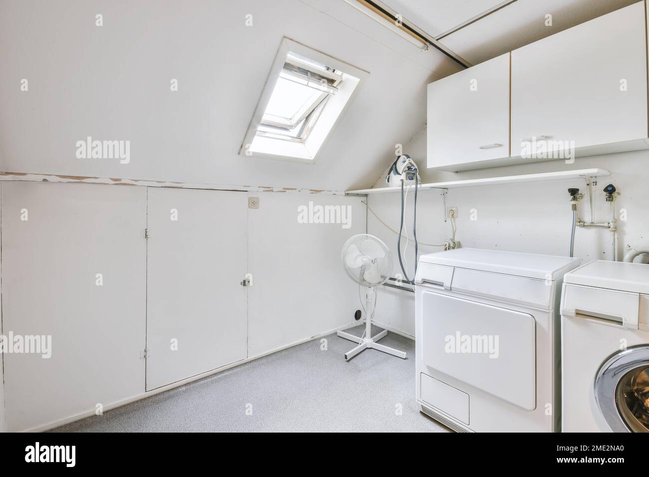 Interior of modern light laundry room with washing machine and tumble ...
