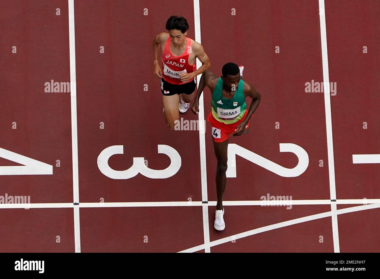 Lamecha Girma, of Ethiopia, and Ryuji Miura, of Japan, finish cthe