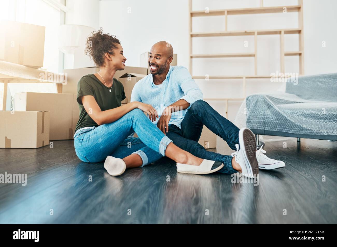 We should start planning our housewarming soon. a young couple taking a break while moving house. Stock Photo