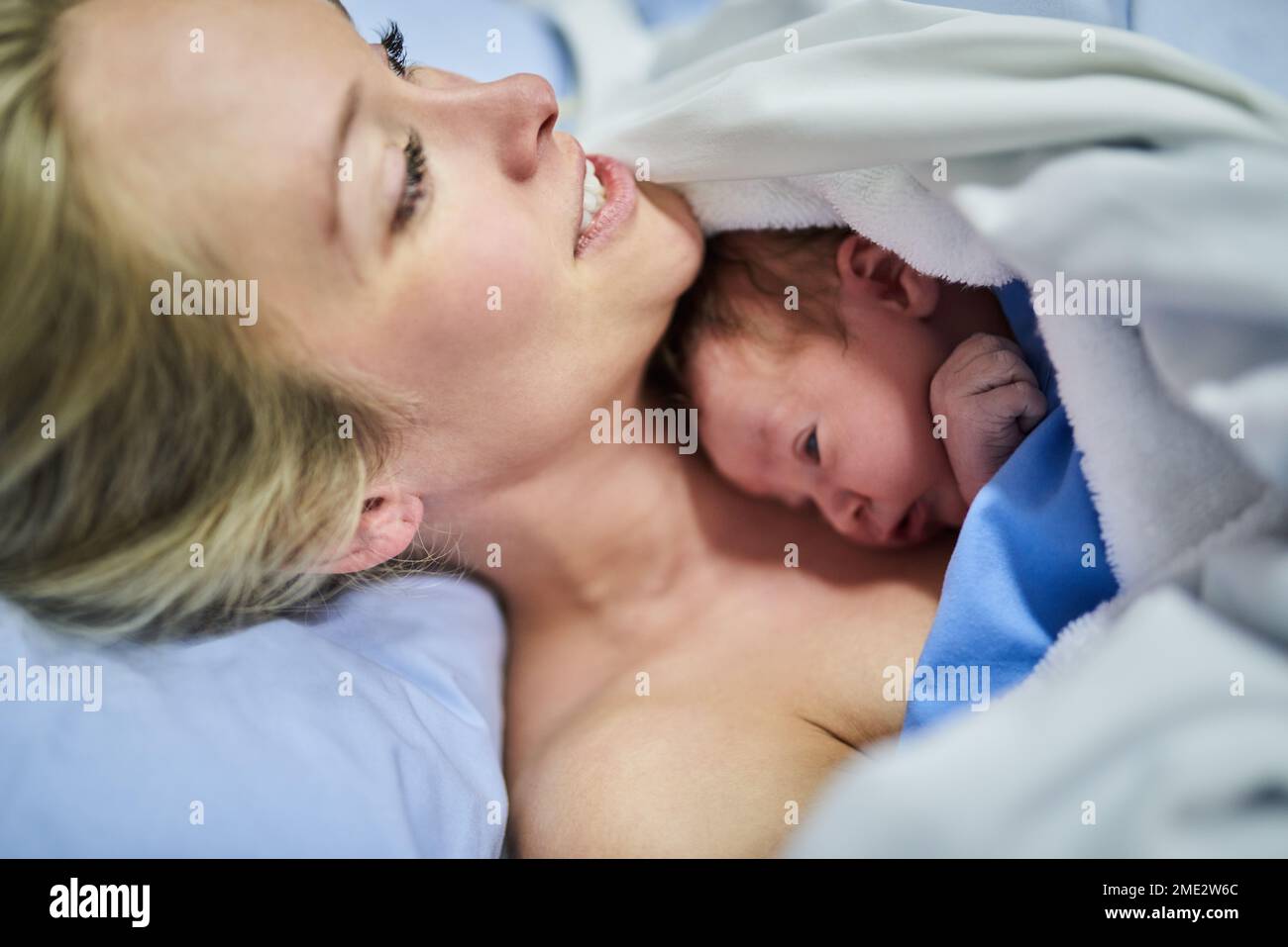 This is what love feels like. a beautiful young mother lying in bed with her newly born baby girl in the hospital. Stock Photo