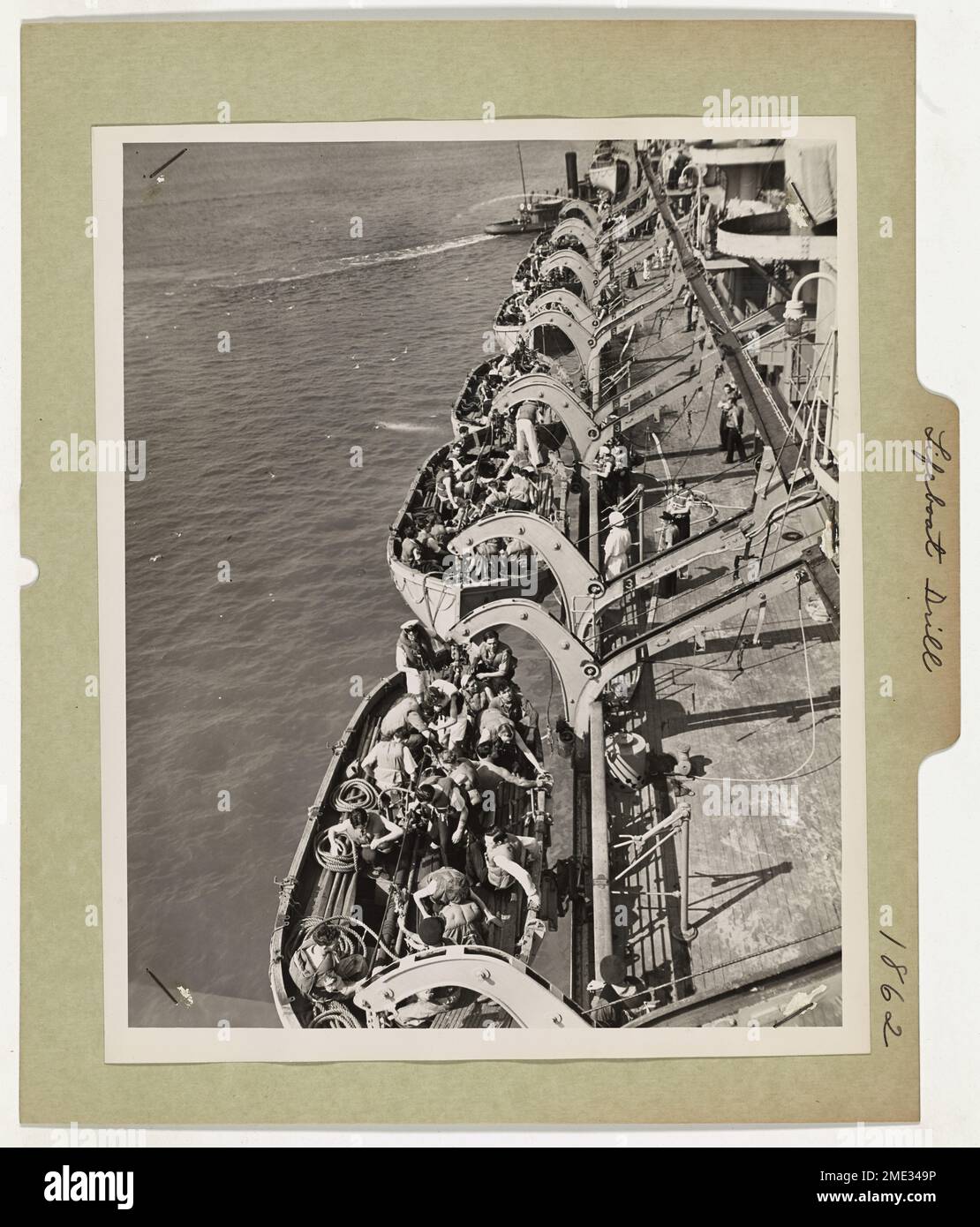 Lifeboat Drill. An American Port - U.S. Coast Guardsmen witness a lifeboat drill conducted by the crew of a Canadian transport prior to its running the gauntlet through submarine infested waters, to a war zone. The U.S. Coast Guard's Merchant Marine Inspection Division conducts rigid lifeboat and fire drills on all ships leaving American ports. Stock Photo