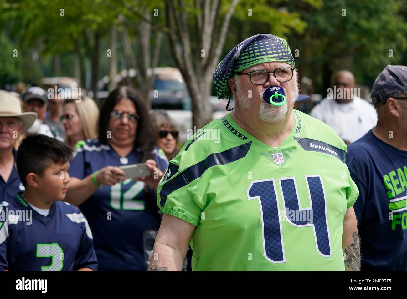 Larry Wales, of Seattle, wears the #14 jersey of Seattle Seahawks wide  receiver DK Metcalf as well as Metcalf's trademark pacifier mouth guard as  he arrives to watch NFL football practice, Wednesday,