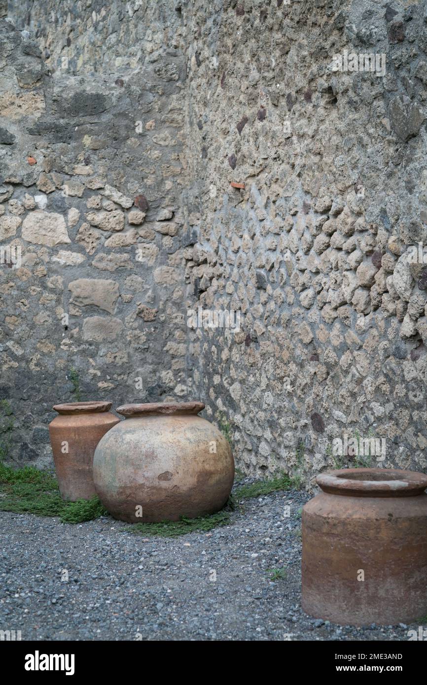 Excavated stone wall and clay pots at the ancient Roman city of Pompeii, an archaeological UNESCO World Heritage Site in Pompei, Campania, Italy. Stock Photo