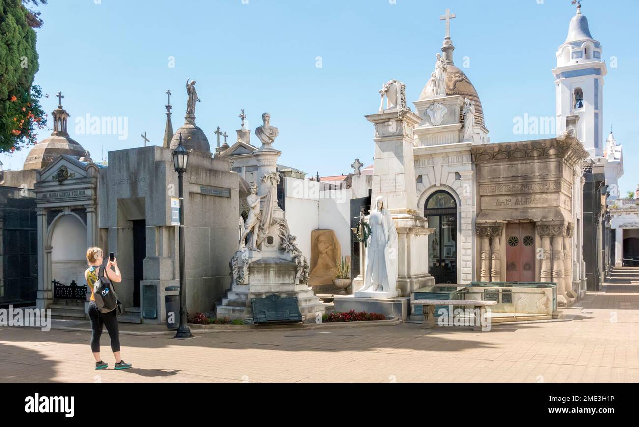 A woman takes photographs with a smartphone in the cemetery at Recoleta, Buenos Aires, Argentina Stock Photo