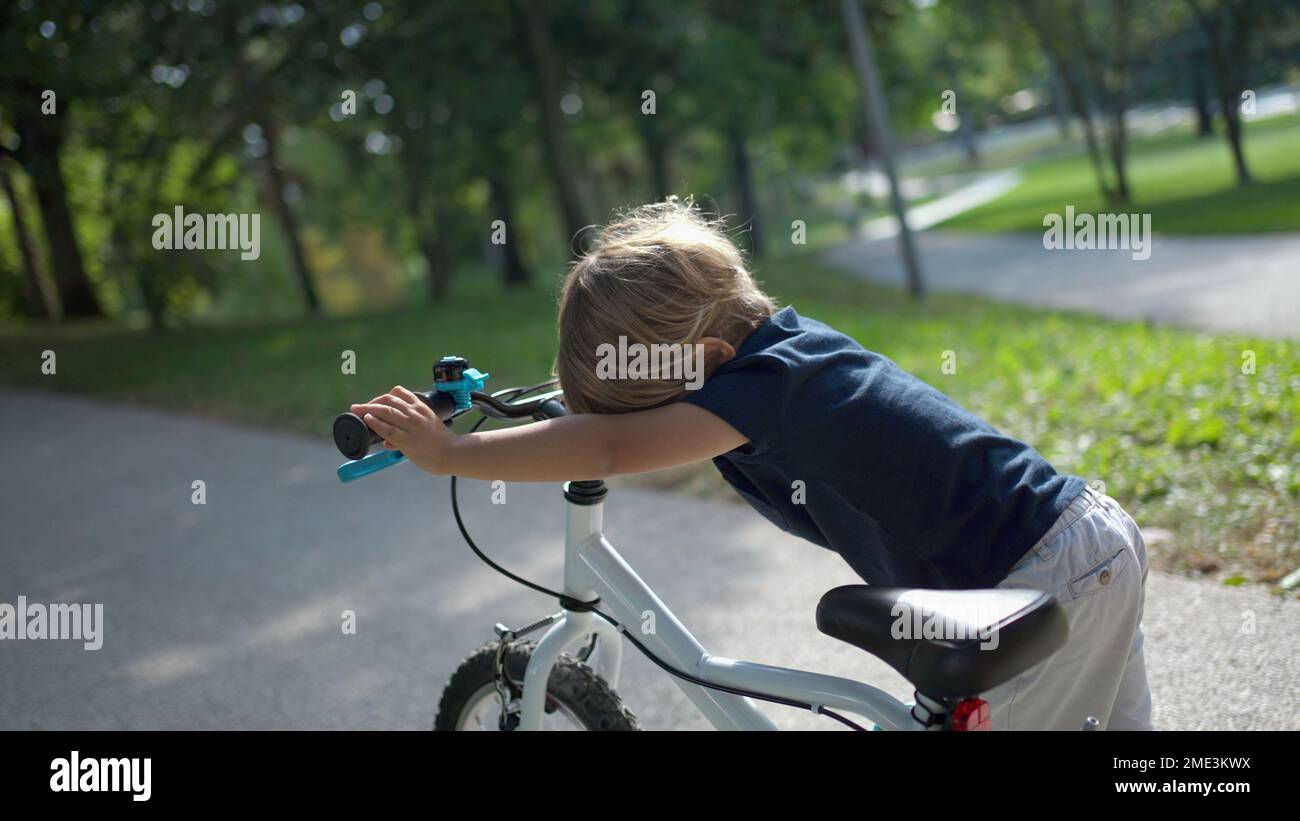 Kid Racking A Bike Child carrying bicycle outside at park one little boy carries bike ...