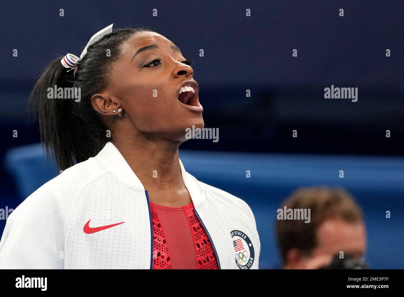 Simone Biles, of the United States, cheers for teammates after she