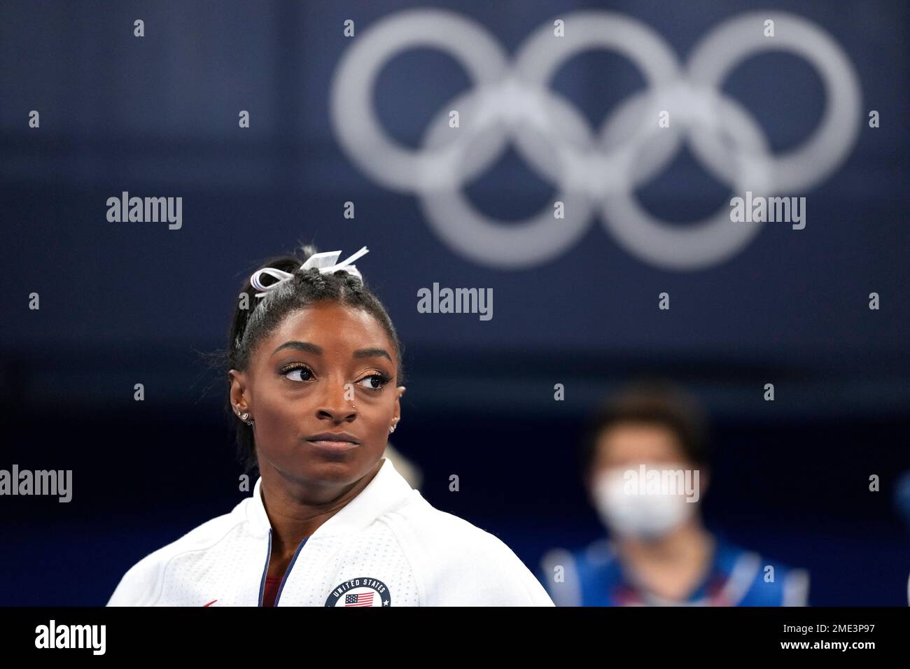 Simone Biles, of the United States, watches gymnasts perform after she