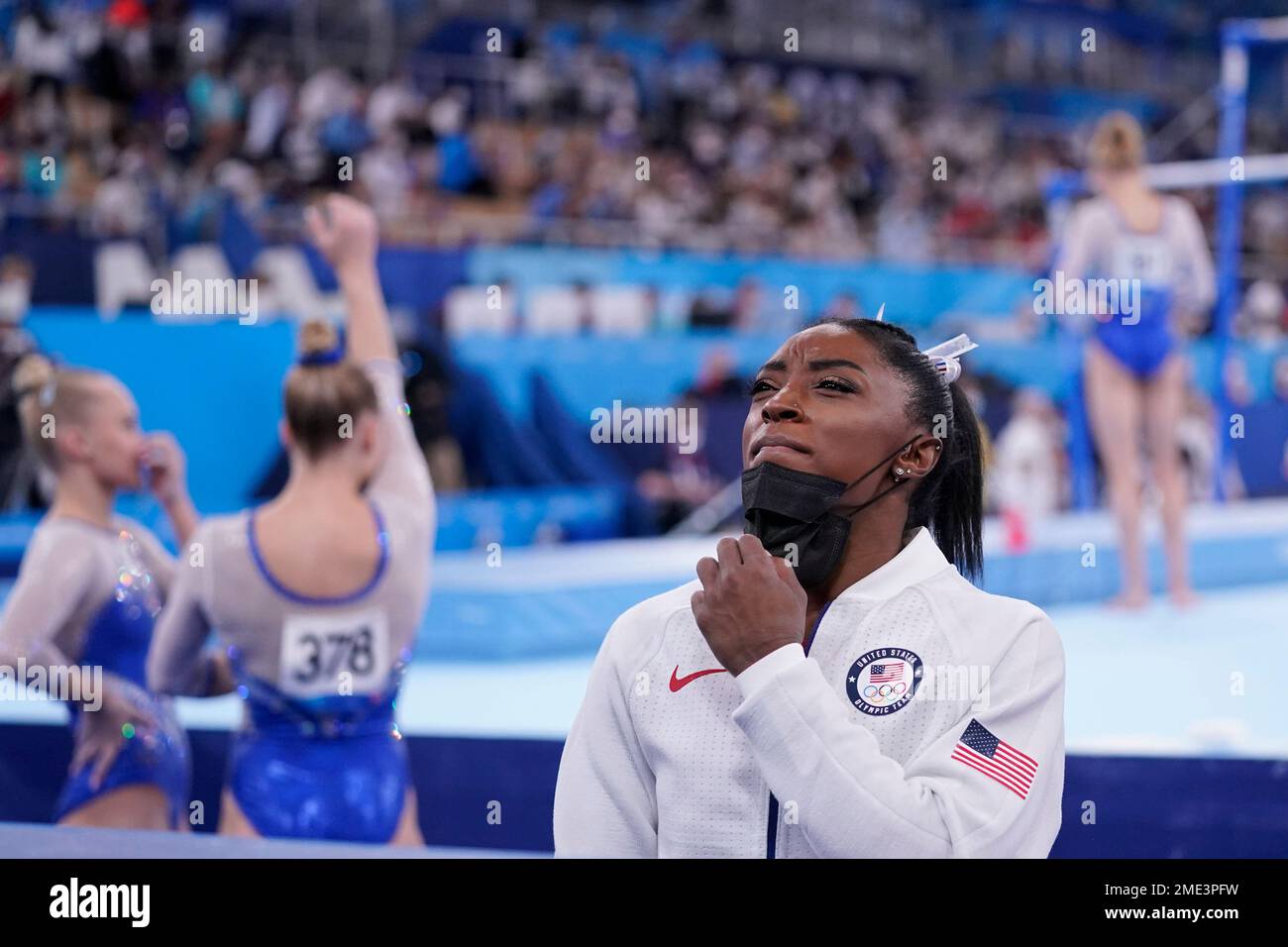 Simone Biles, of the United States, stands holding her mask after she