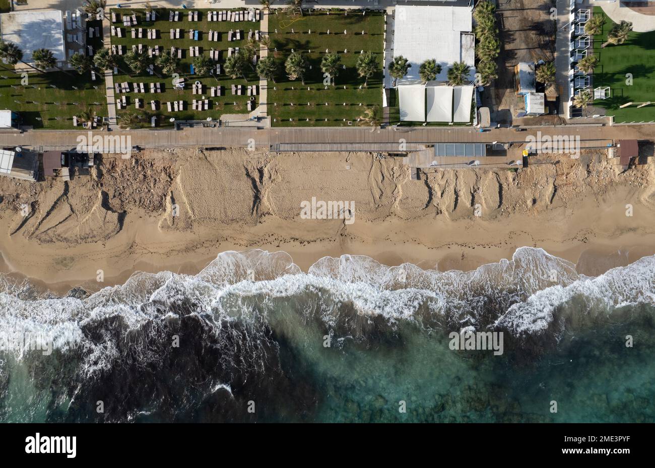 Aerial view of ocean waves breaking on a sandy beach. Beach erosion after coastal flooding. Protaras Cyprus. Stock Photo