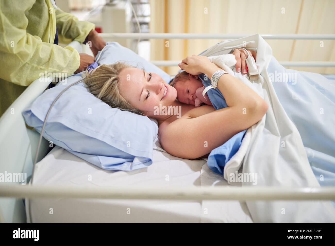 The greatest joy on earth. a beautiful young mother lying in bed with her newly born baby girl in the hospital. Stock Photo