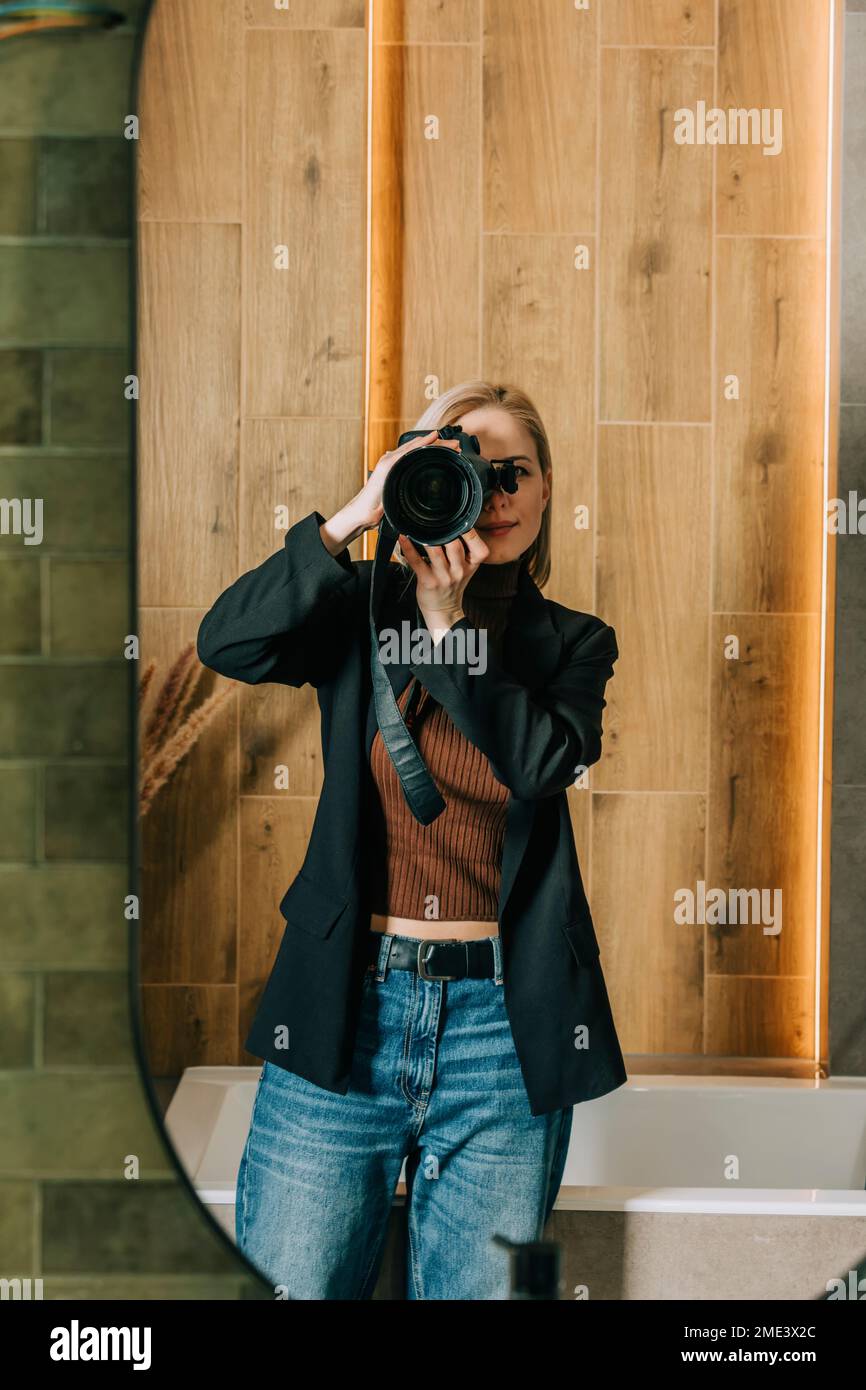 Woman photographing through camera seen in bathroom mirror Stock Photo