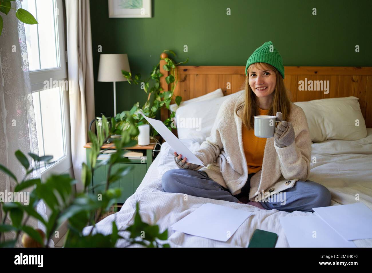 Happy woman with financial bills sitting on bed at home Stock Photo Alamy