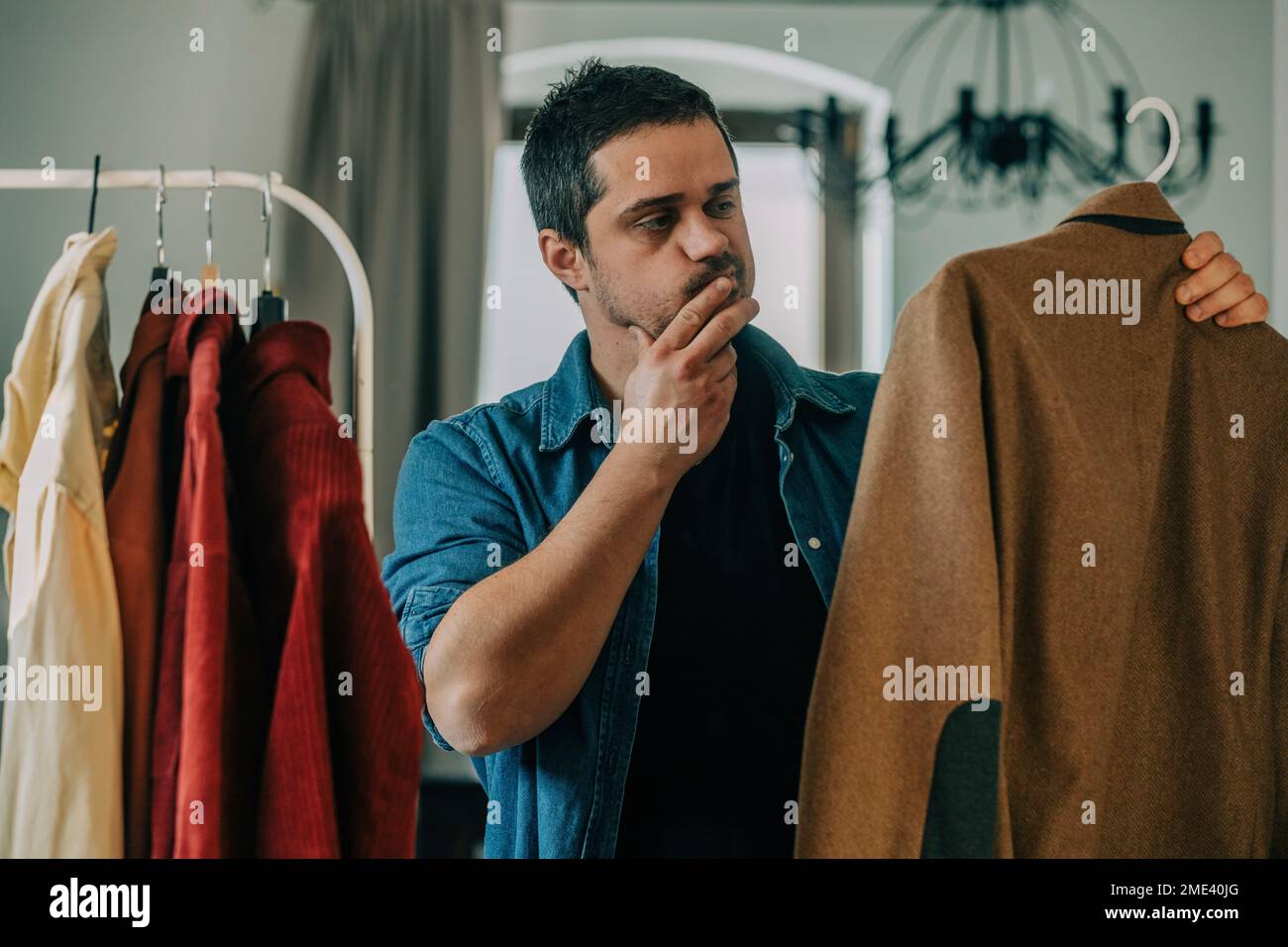 Man choosing clothes at home Stock Photo