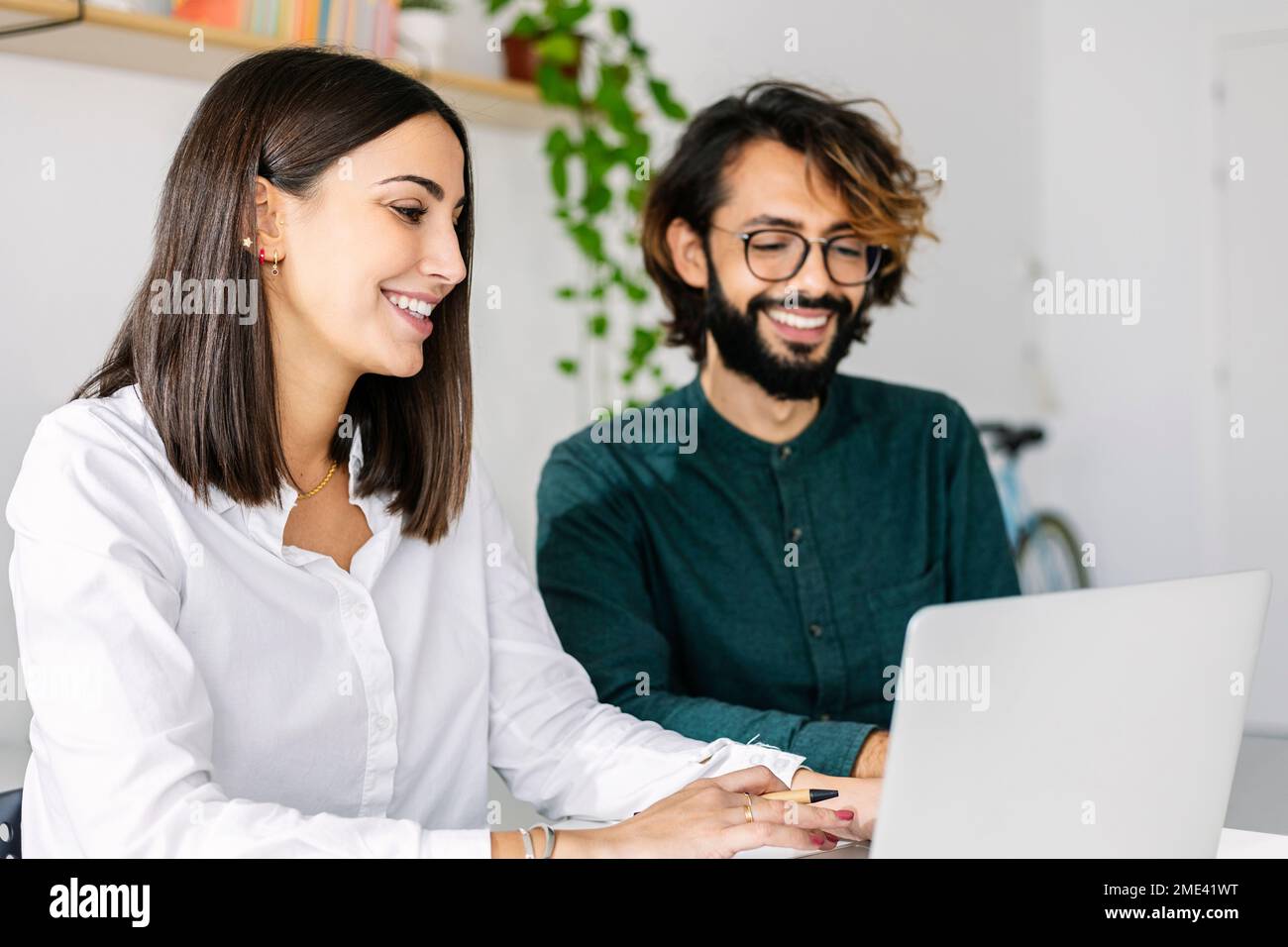 Happy business colleagues working on laptop at office Stock Photo