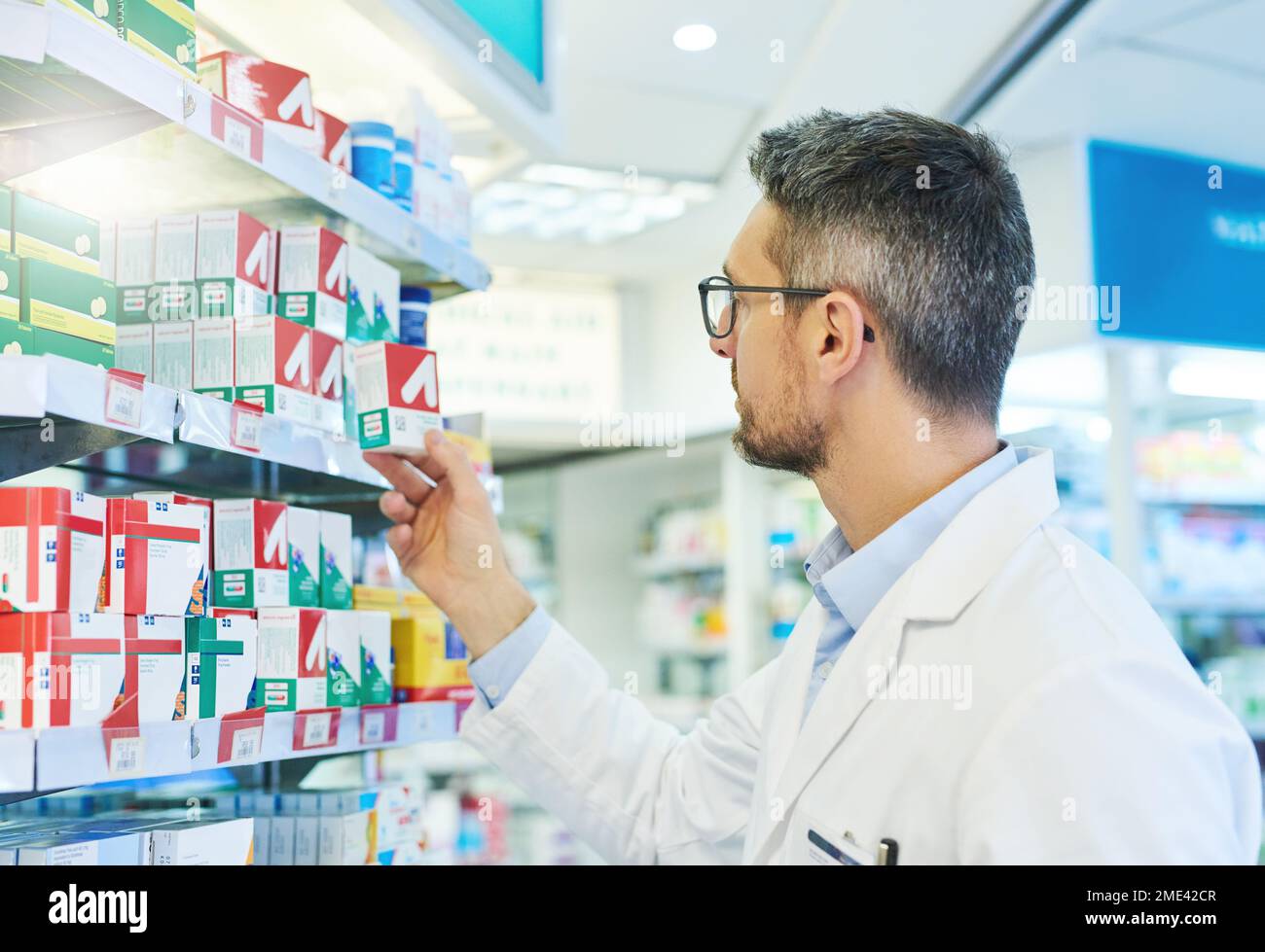 Trust him to get you well in no time. a mature pharmacist working in a pharmacy. Stock Photo