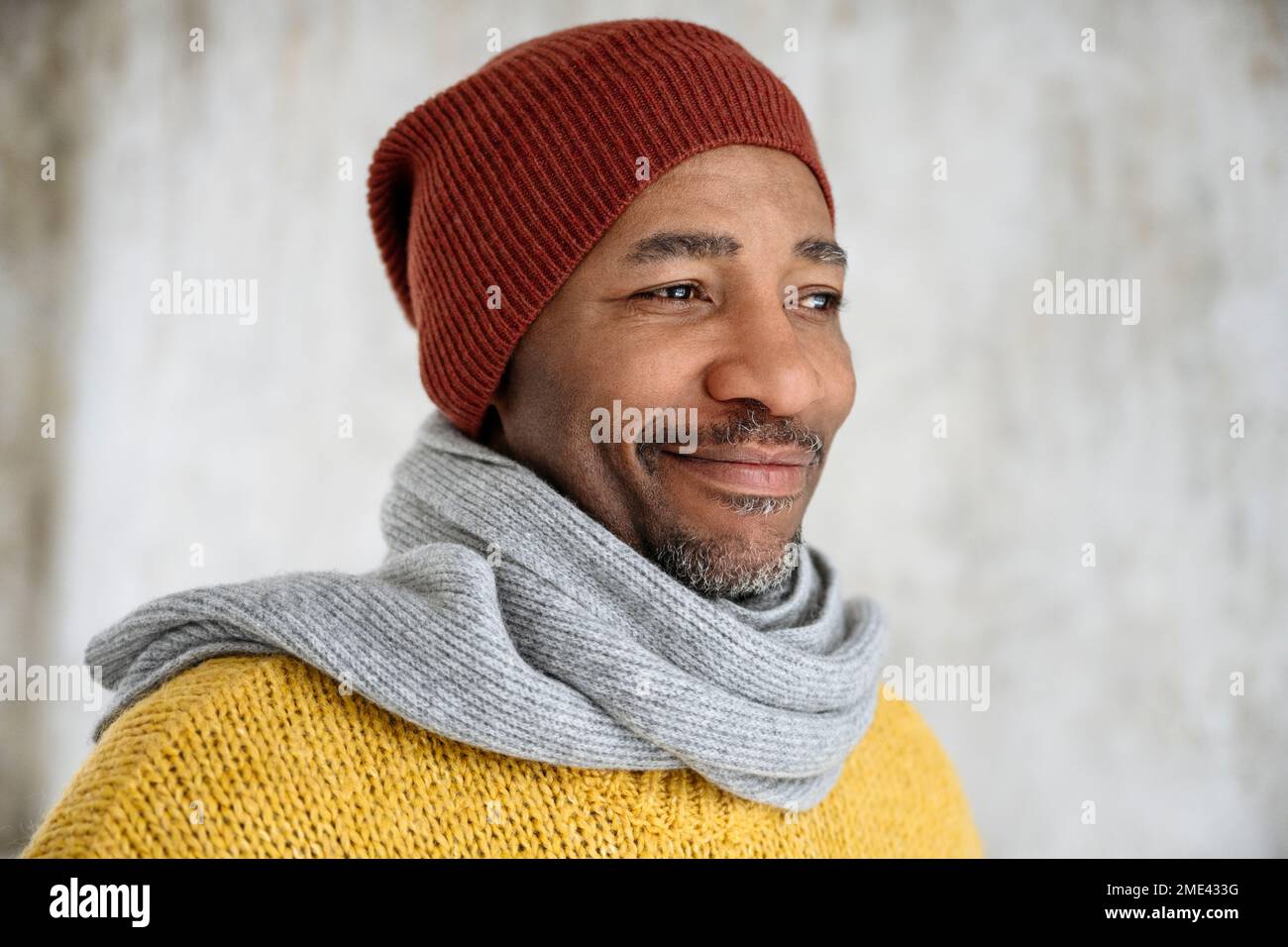 Smiling man wearing scarf and knit hat Stock Photo