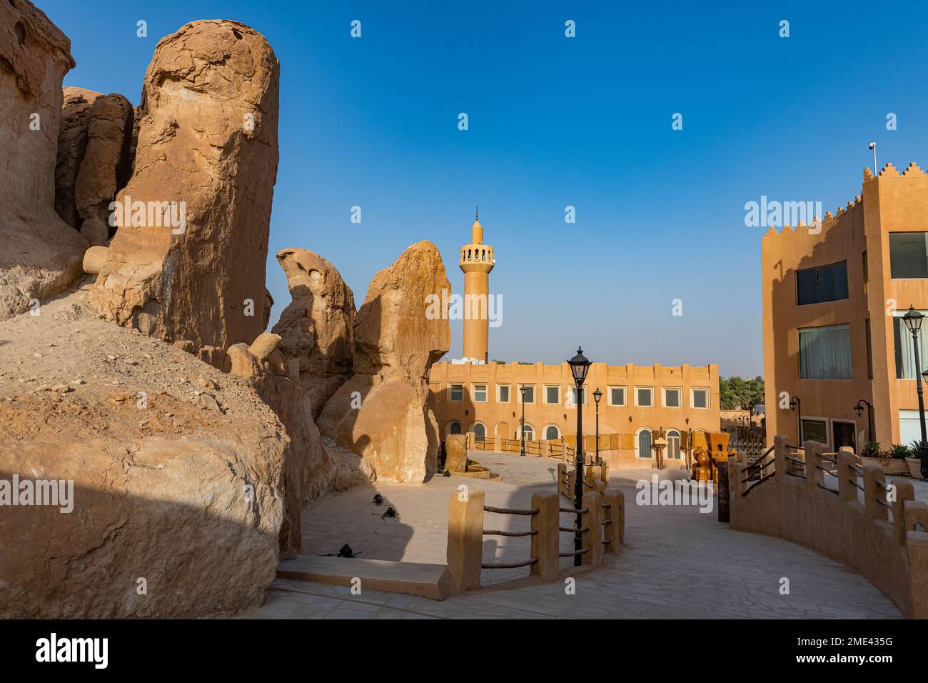 Saudi Arabia, Eastern Province, Al-Hofuf, Sandstone outcrops with mosque in background Stock Photo