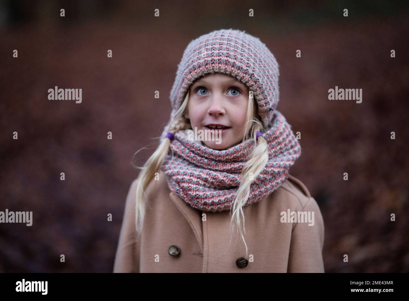 Smiling blond girl wearing knit hat and scarf Stock Photo
