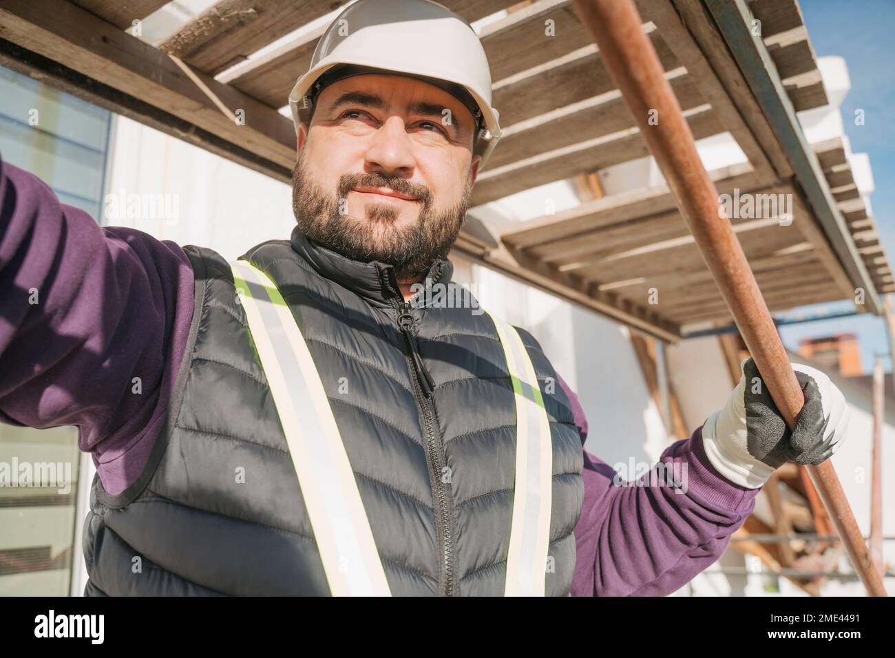 Construction worker holding metal rebar in front of house Stock Photo