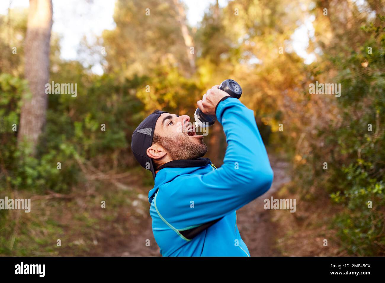 Man drinking water in forest Stock Photo
