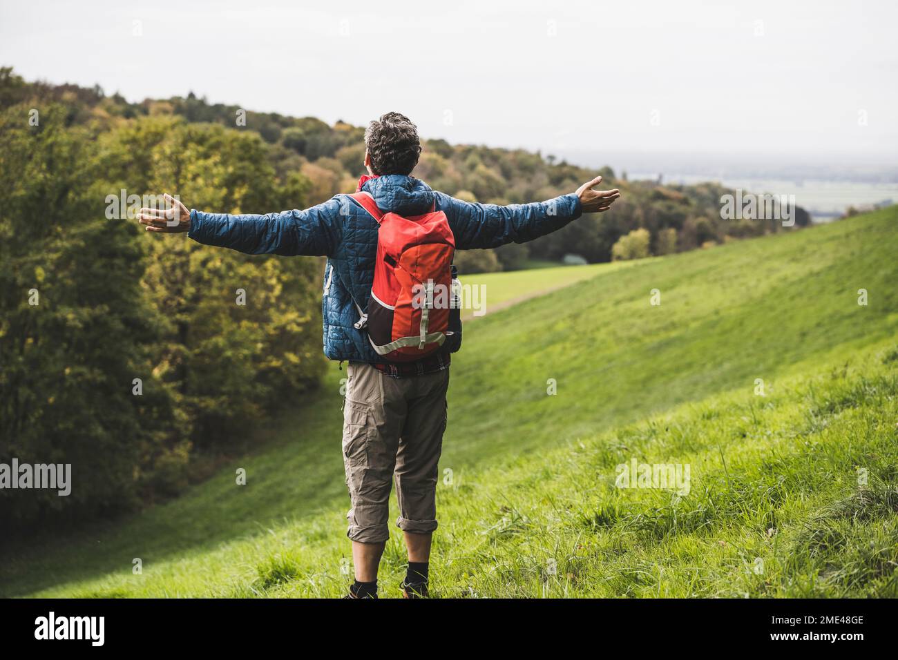 Man backpack standing arms hi-res stock photography and images - Alamy