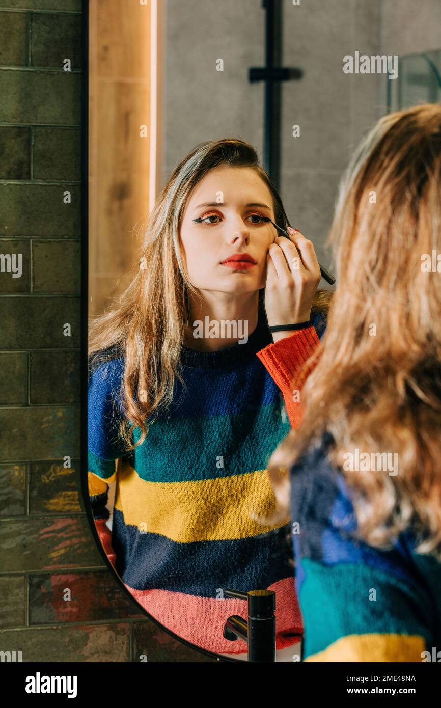Blond girl doing makeup in front of bathroom mirror Stock Photo Alamy