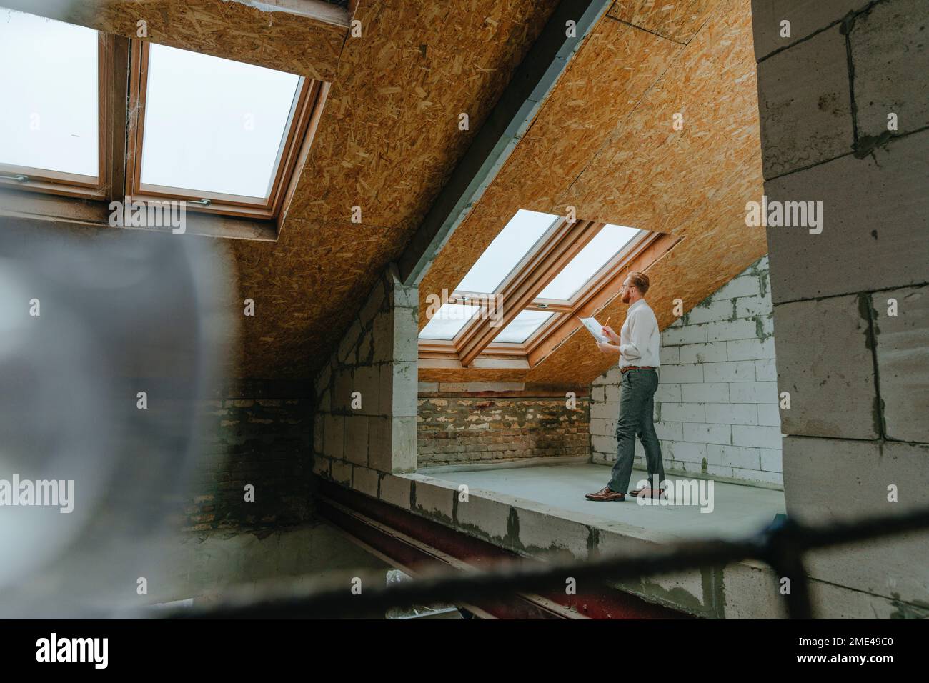 Architect examining blueprint at construction site Stock Photo