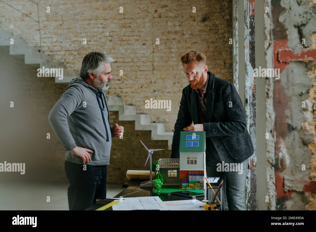 Architect explaining customer model house at construction site Stock ...