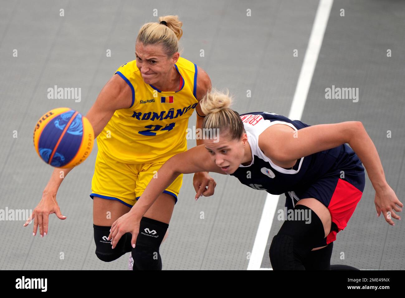 Ancuta Stoenescu, left, of Romania, and Olga Frolkina, of the Russian  Olympic Committee, chase a loose ball during a women's 3-on-3 basketball  game against Romania at the 2020 Summer Olympics, Monday, July