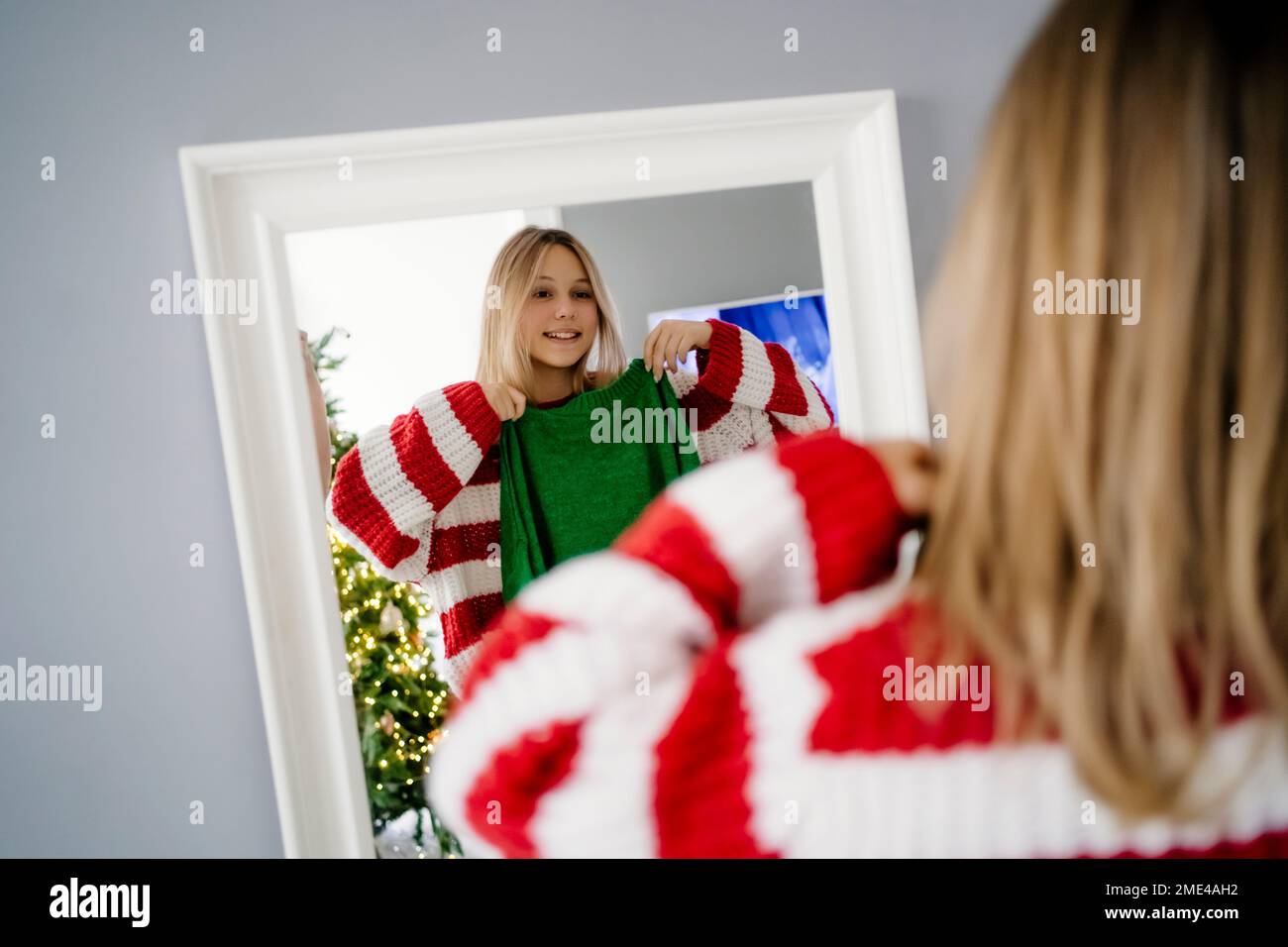Happy girl trying clothes standing in front of mirror at home Stock Photo