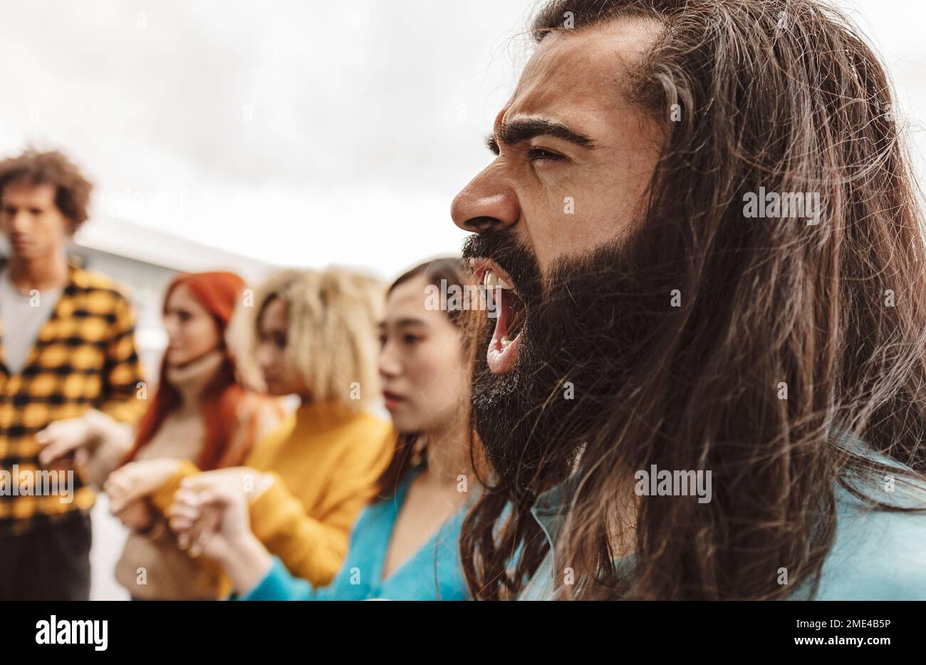 Rebellion hipster man screaming with activists at protest Stock Photo