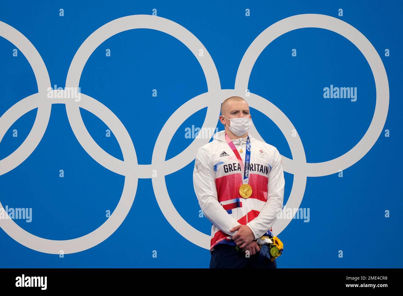 Adam Peaty of Britain stands on the podium after winning the final of