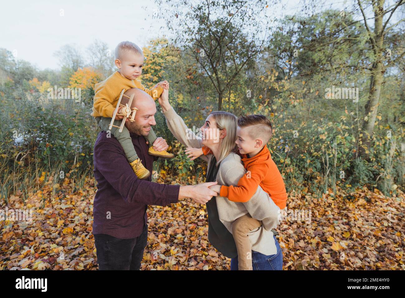 Happy parents with children enjoying in autumn forest Stock Photo
