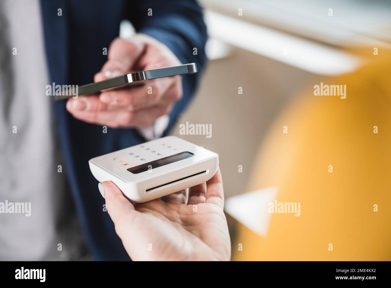Hand of businessman paying with smart phone on card reader machine Stock Photo