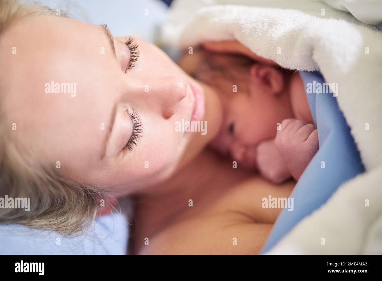 Shes just warmed up my heart. a beautiful young mother lying in bed with her newly born baby girl in the hospital. Stock Photo
