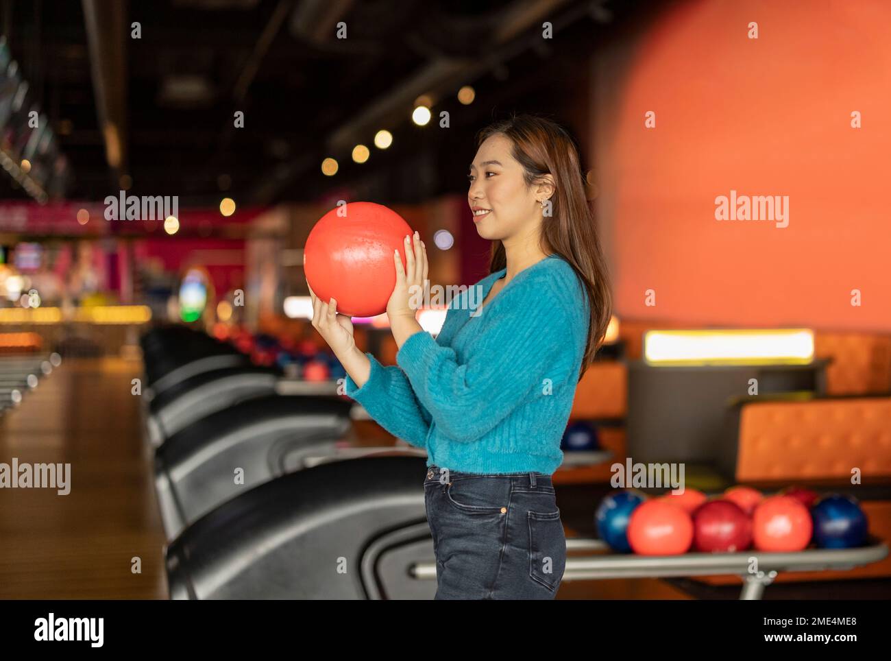 Young woman holding bowling ball at alley Stock Photo Alamy