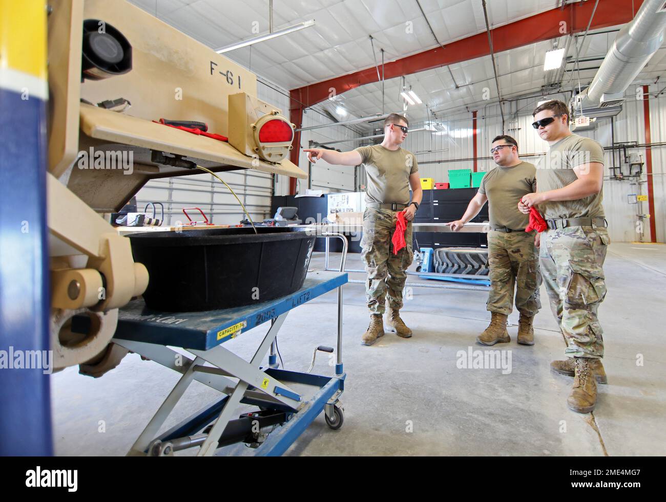 Army Reserve Pfc. Tyler Kirkland assigned to the 390th Engineer Company, 412th Theater Engineer Command based in Chattanooga, Tenn., left, explains to fellow company Soldiers how a Light Capability Rough Terrain Forklift works seconds after they began draining hydraulic fluid from one in order to replace a temperature sending unit during the first-ever Field Maintenance Level Course for the LCRTF at the 88th Readiness Division-operated Draw Yard on Fort McCoy, Wis., July 27, 2022. The LCRTF is a C-130 and CH-47 sling load transportable, 5,000-pound capacity, variable-reach, rough-terrain forkl Stock Photo