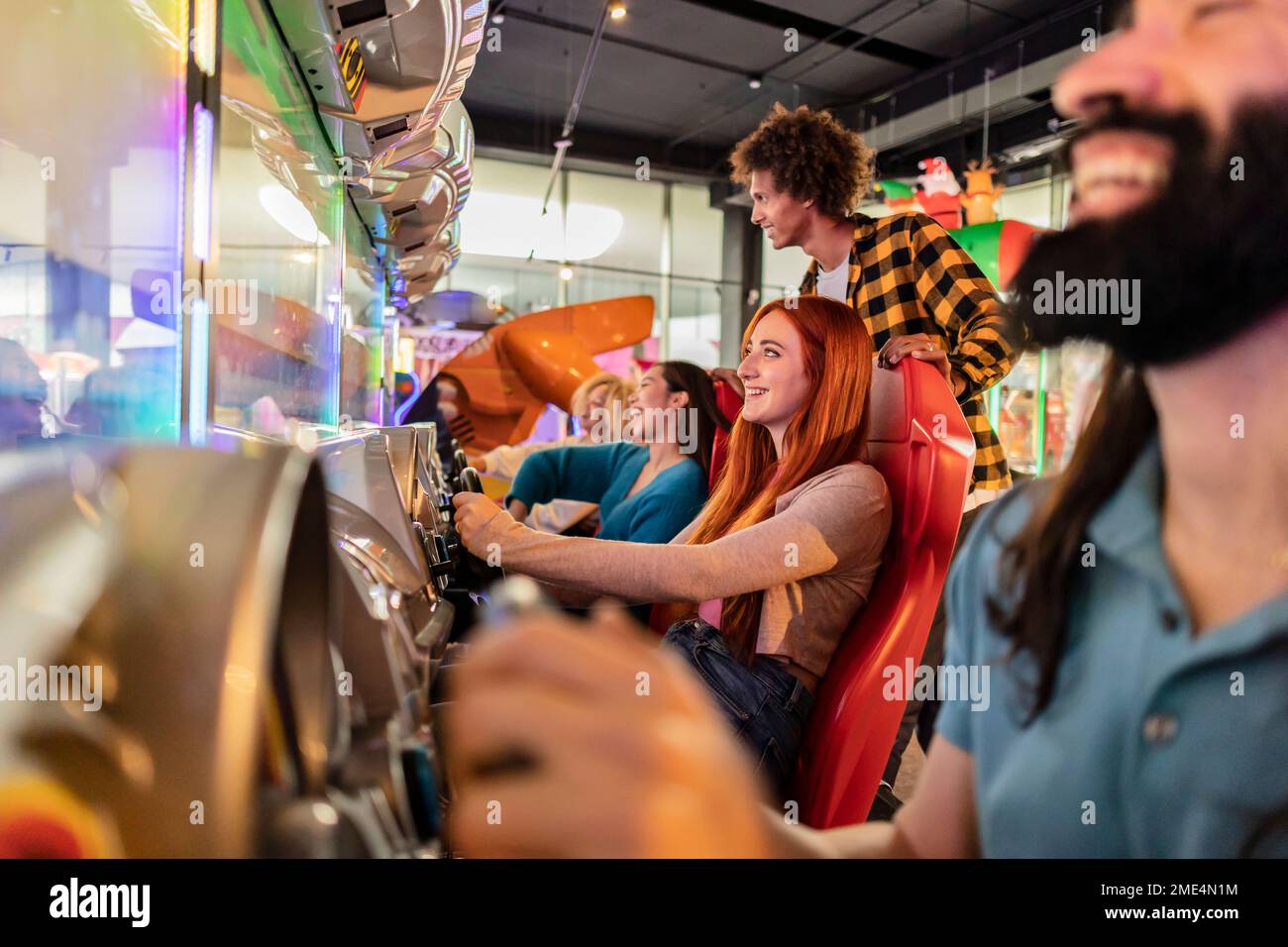 Happy young women having fun with driving simulator in arcade Stock ...