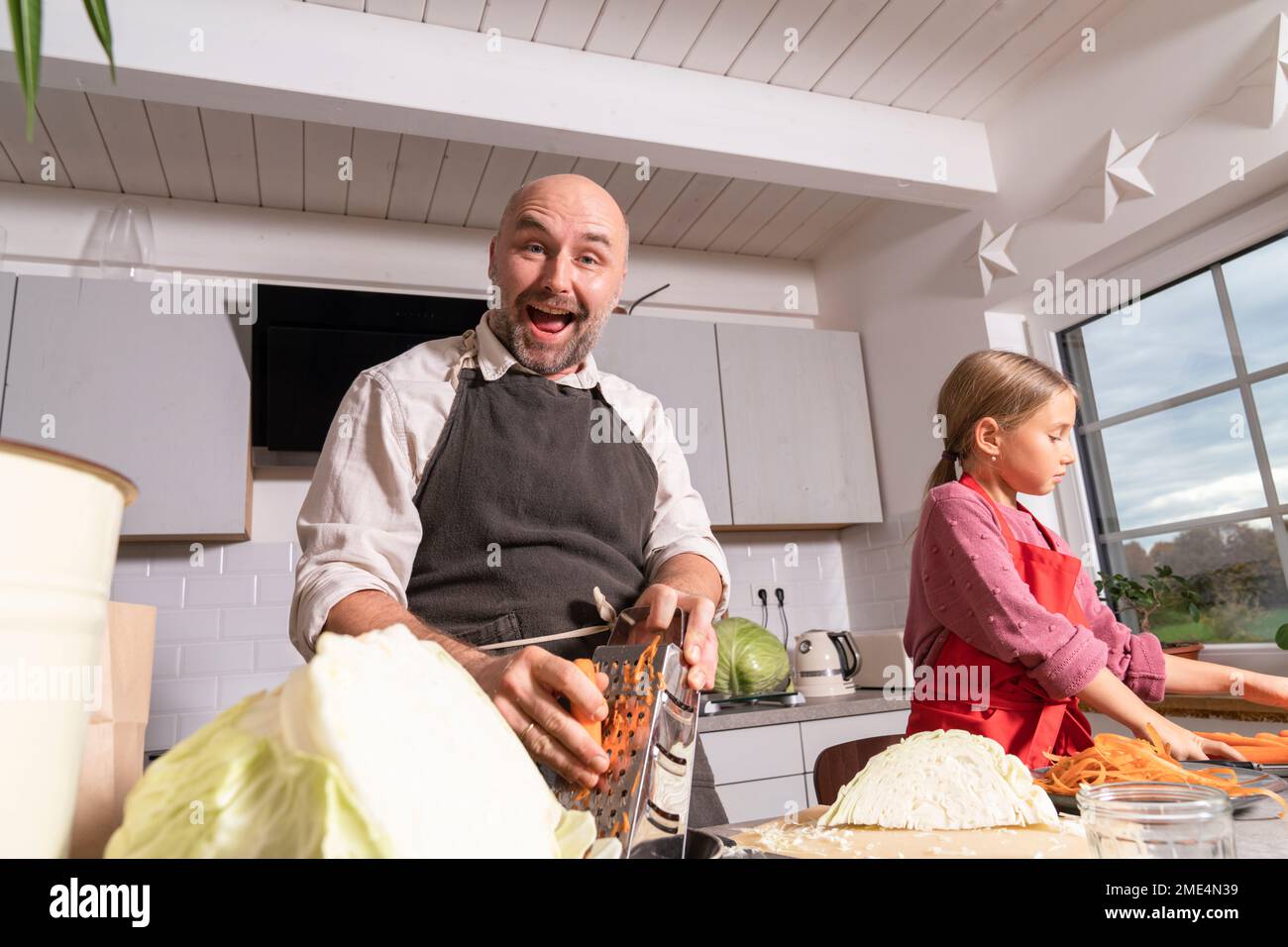 Happy father and daughter preparing healthy meal in kitchen at home ...
